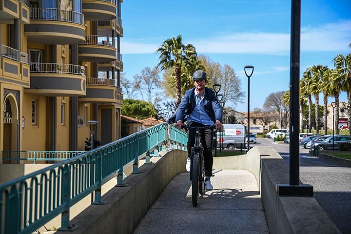 A man in a suit riding an e-bike in the city