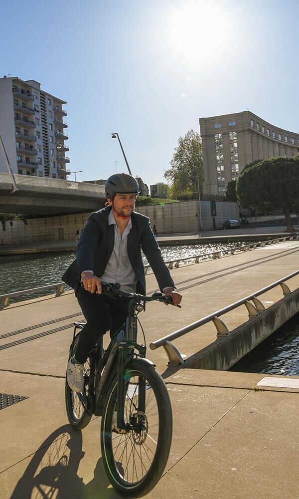 A smart dressed man riding an ebike in the city